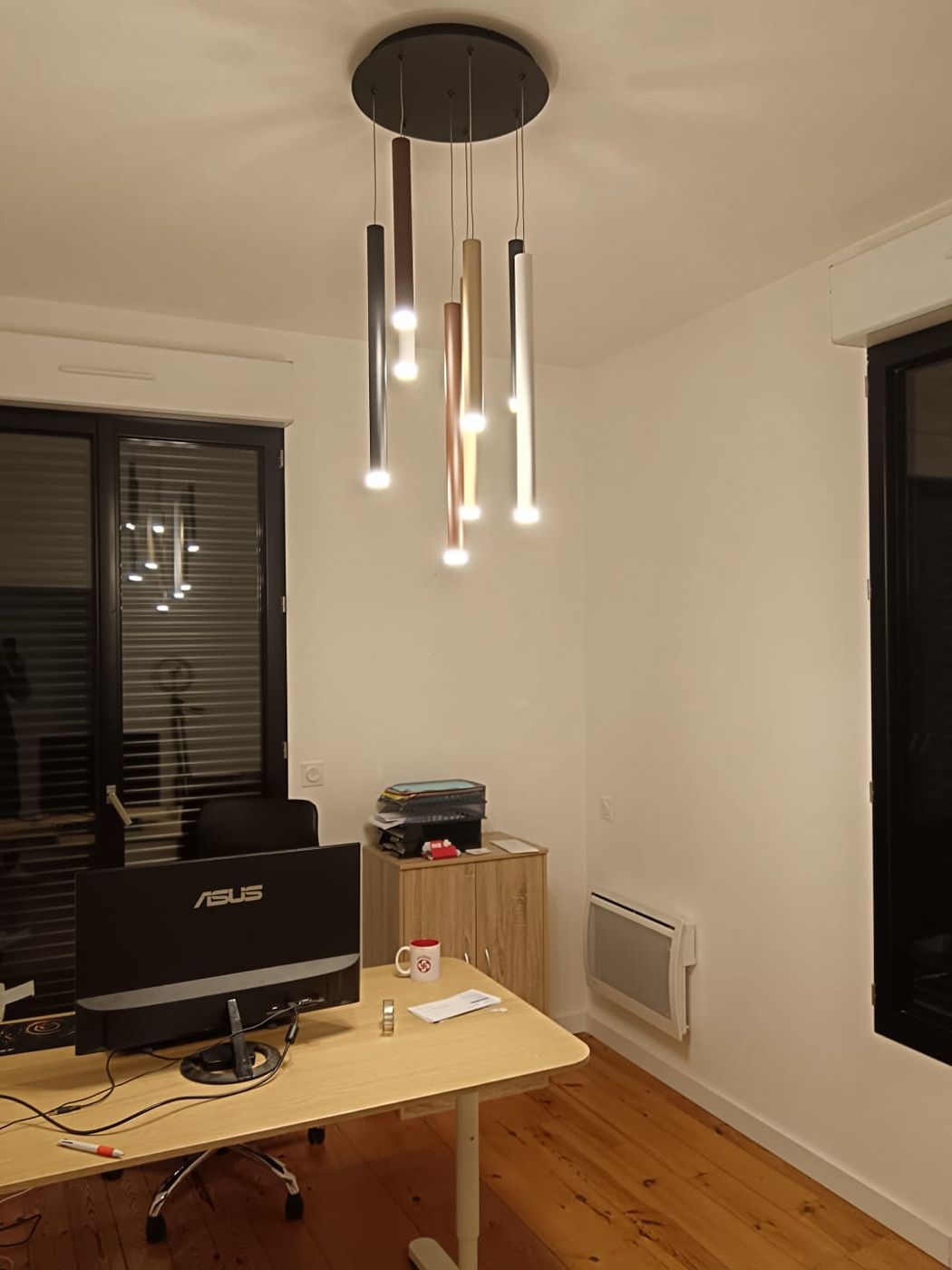 Bureau éclairé par une suspension à tubes LED de couleurs