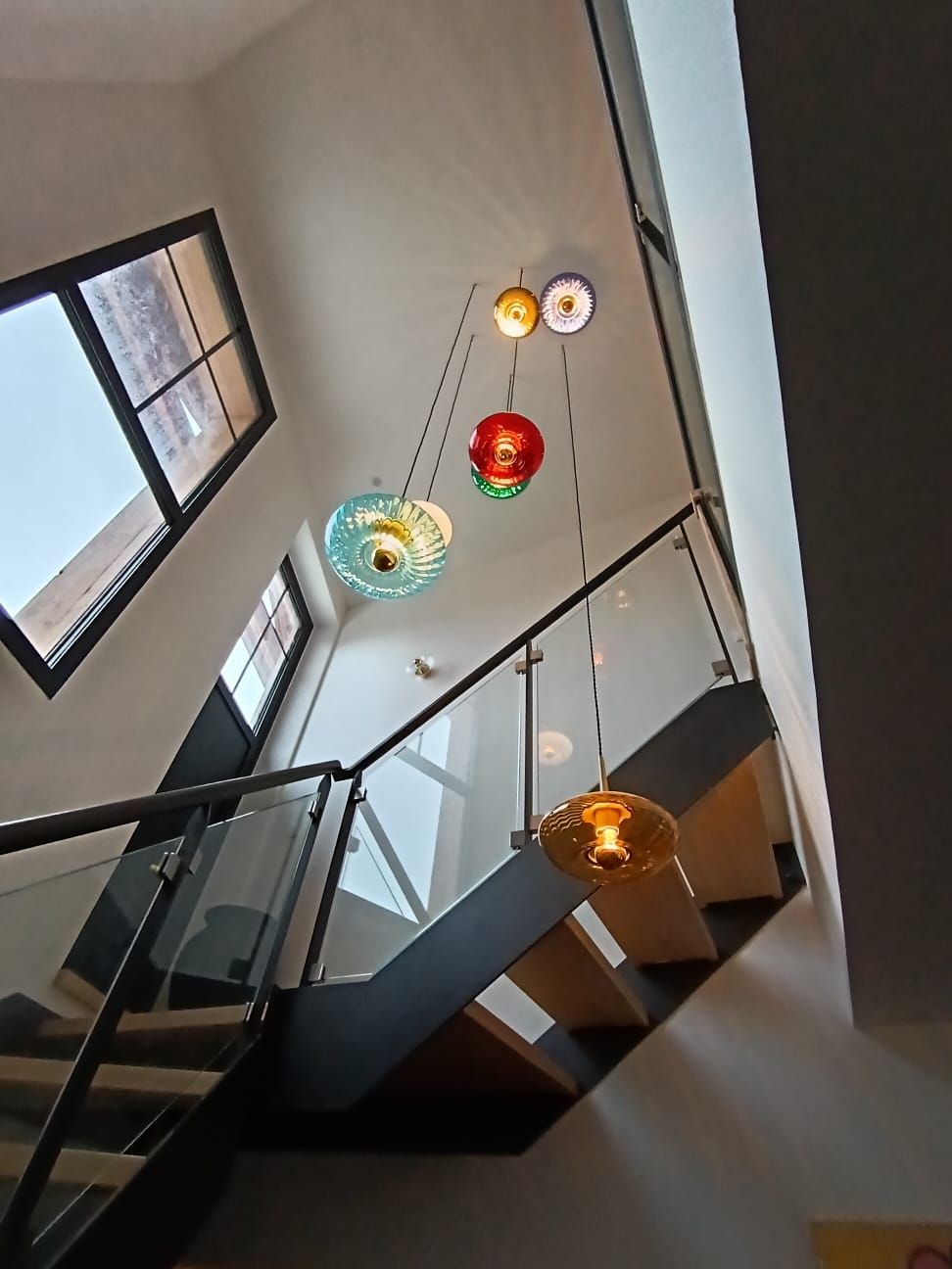 Cage d'escalier ornée de suspensions en verre coloré