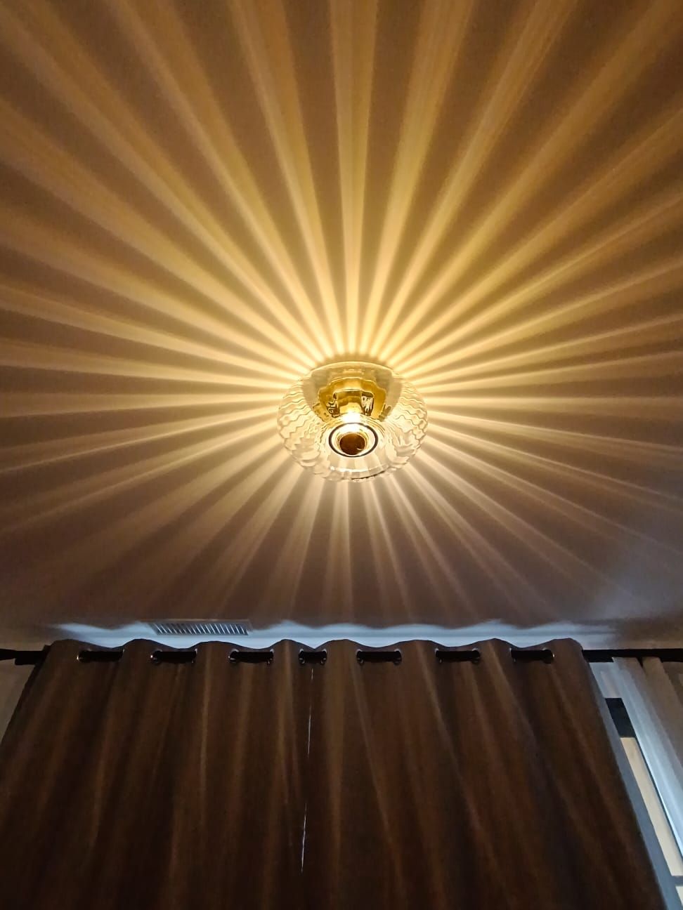 Plafonnier en verre ciselé projetant des rayons de lumière